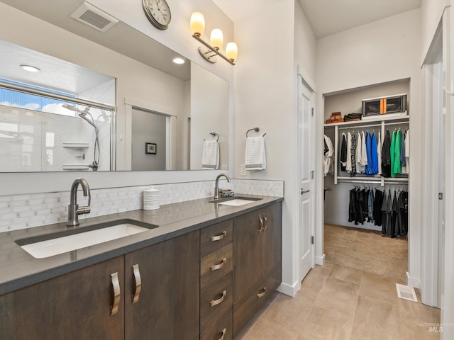 10366 Loneleaf Dr, Nampa, ID 83687 - bathroom featuring double vanity, backsplash, a spacious closet, and tile patterned floors