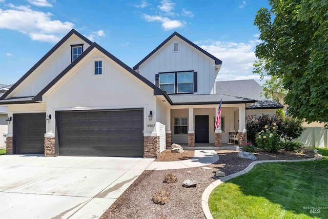 4462 N Stampede Way, Meridian, ID 83642 - view of front of property featuring stone siding, board and batten siding, a garage, a porch, and concrete driveway