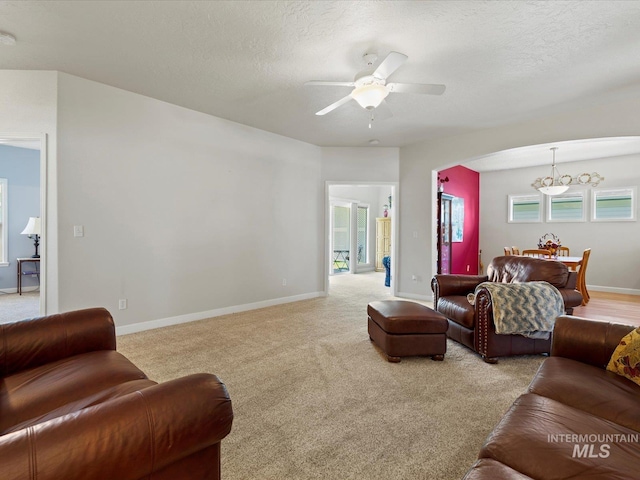 3369 W Monessen Ln, Meridian, ID 83646 - living room featuring arched walkways, a ceiling fan, carpet flooring, a chandelier, and a textured ceiling