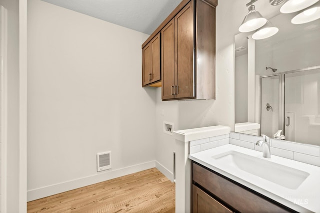 202 Broken Pne, Mccall, ID 83638 - full bathroom with a stall shower, wood finished floors, vanity, and baseboards