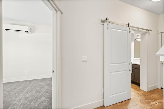202 Broken Pne, Mccall, ID 83638 - corridor featuring a wall unit AC, baseboards, a barn door, and light wood-style flooring