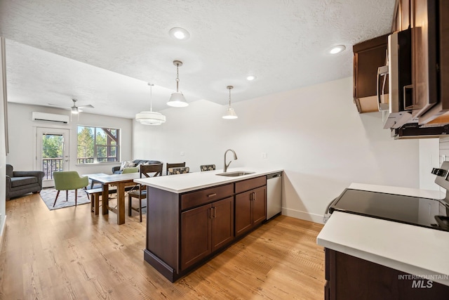 202 Broken Pne, Mccall, ID 83638 - kitchen with appliances with stainless steel finishes, a sink, a peninsula, a wall mounted AC, and open floor plan