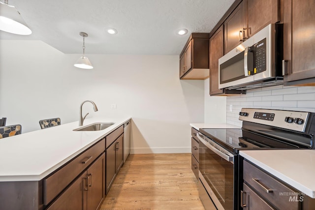 202 Broken Pne, Mccall, ID 83638 - kitchen with appliances with stainless steel finishes, a sink, a peninsula, baseboards, and decorative backsplash