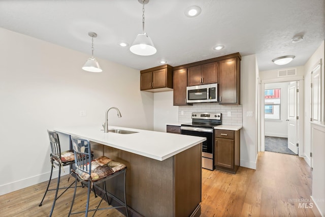 202 Broken Pne, Mccall, ID 83638 - kitchen with stainless steel appliances, a sink, baseboards, a kitchen breakfast bar, and light countertops