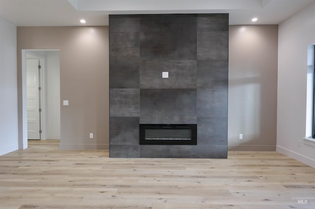 interior details featuring hardwood / wood-style flooring and a tiled fireplace