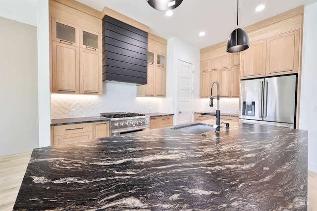 kitchen featuring sink, stainless steel appliances, light brown cabinetry, custom range hood, and light wood-type flooring