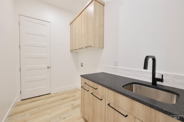 kitchen with light brown cabinetry, sink, and light hardwood / wood-style flooring