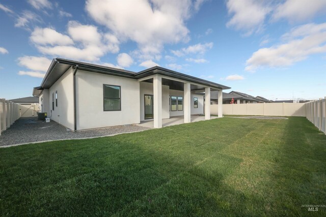 back of house with a lawn, a patio area, and central air condition unit