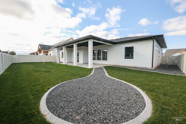 back of property featuring a lawn and a patio area