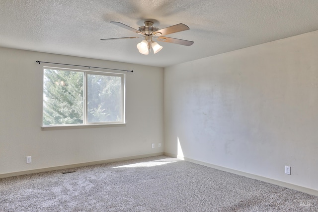 carpeted empty room with visible vents, baseboards, a textured ceiling, and ceiling fan