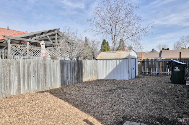 view of yard featuring a storage shed, an outbuilding, and a fenced backyard