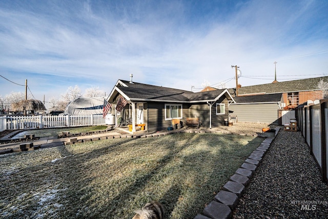 rear view of property featuring a lawn