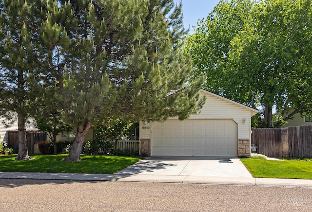 view of property hidden behind natural elements with stone siding, concrete driveway, and a garage