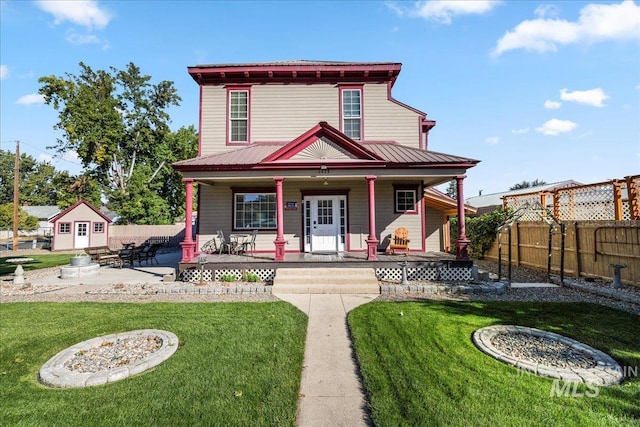 view of front of home with an outbuilding, a front yard, a patio, and a porch