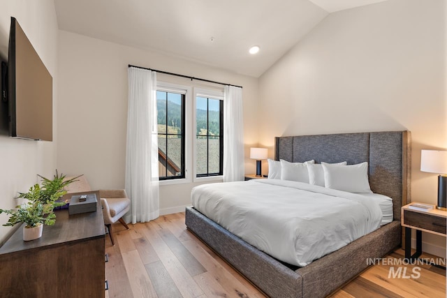 bedroom with lofted ceiling and light hardwood / wood-style flooring