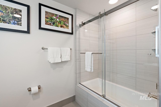 bathroom featuring bath / shower combo with glass door