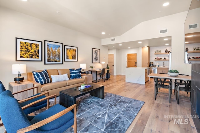 living room with hardwood / wood-style flooring and vaulted ceiling