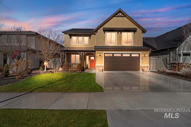 view of front of house featuring covered porch, a yard, and a garage