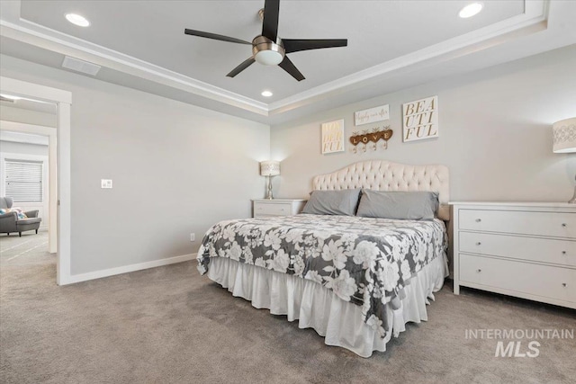 carpeted bedroom with ceiling fan, crown molding, and a raised ceiling