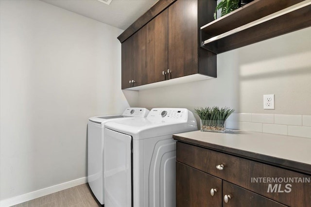 washroom with cabinets and washer and clothes dryer