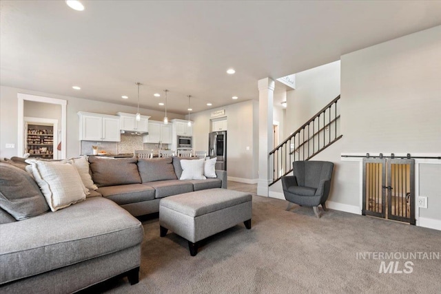 living room featuring ornate columns and carpet