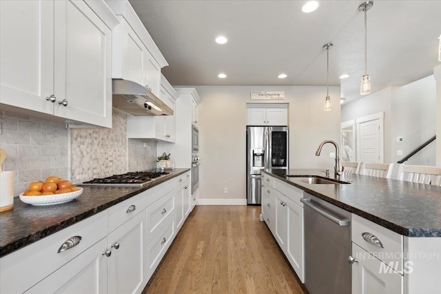 kitchen featuring white cabinetry, an island with sink, appliances with stainless steel finishes, pendant lighting, and sink