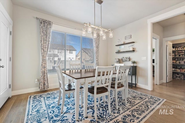 dining area featuring light hardwood / wood-style floors and a chandelier