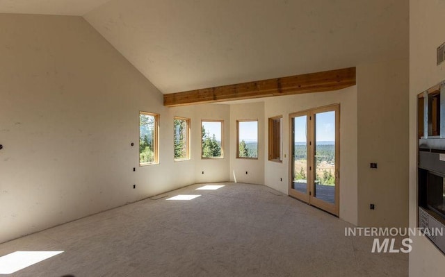 unfurnished room with light carpet and lofted ceiling with beams