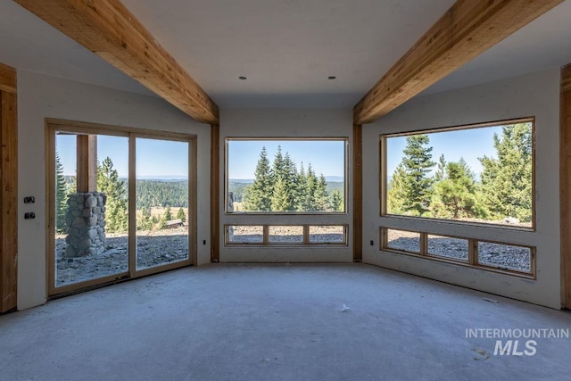 unfurnished sunroom featuring beam ceiling