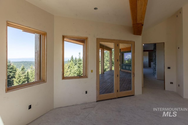 unfurnished room featuring lofted ceiling with beams