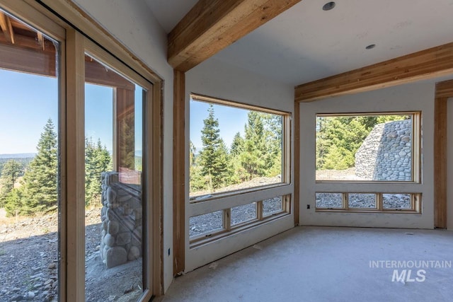 unfurnished sunroom with beam ceiling