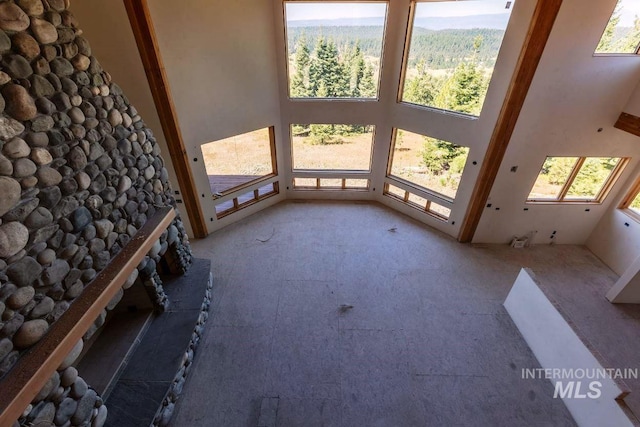 unfurnished living room featuring a high ceiling and plenty of natural light