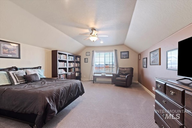 bedroom featuring ceiling fan, a textured ceiling, light carpet, and vaulted ceiling