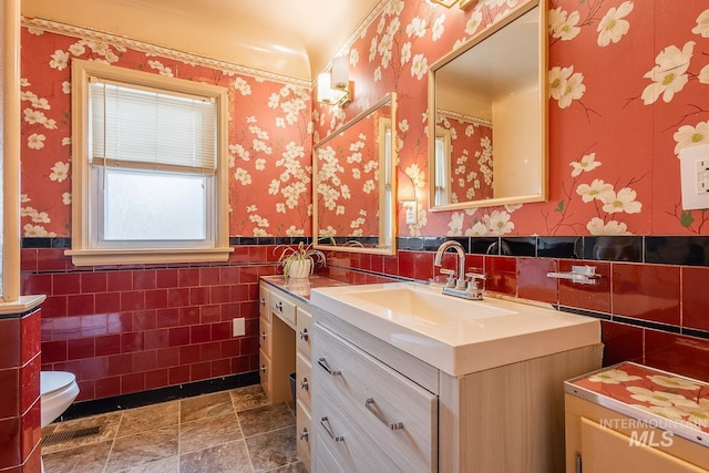 3102 N Sycamore Dr, Boise, ID 83703 - full bath featuring vanity, tile walls, a wainscoted wall, wallpapered walls, and toilet
