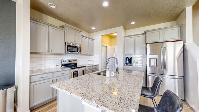 161 S Baraya Way, Meridian, ID 83642 - kitchen with appliances with stainless steel finishes, a sink, gray cabinets, light stone countertops, and recessed lighting