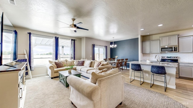 161 S Baraya Way, Meridian, ID 83642 - living area with a textured ceiling, a chandelier, light wood-style flooring, a ceiling fan, and baseboards