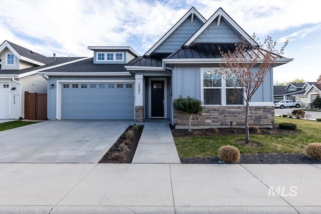 craftsman-style home with board and batten siding, a standing seam roof, driveway, stone siding, and a garage