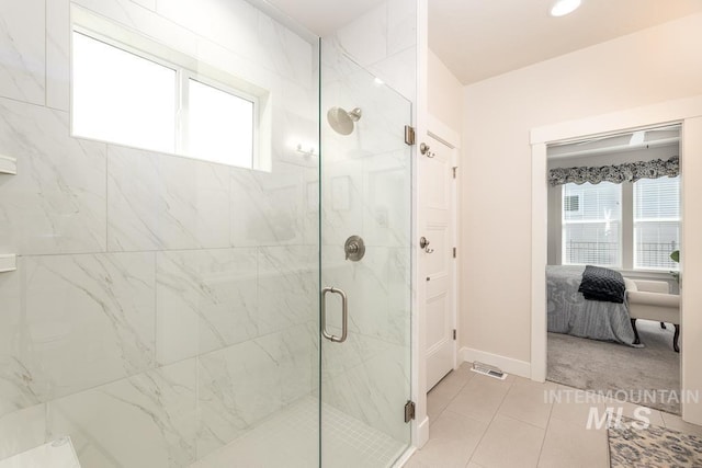 ensuite bathroom with tile patterned floors, a marble finish shower, visible vents, baseboards, and connected bathroom