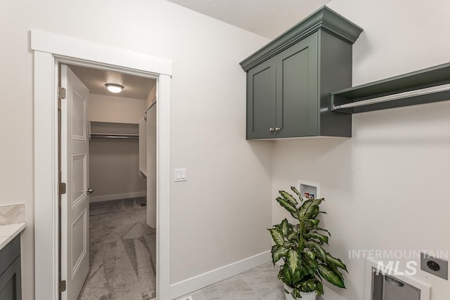 washroom featuring baseboards, washer hookup, hookup for an electric dryer, and cabinet space
