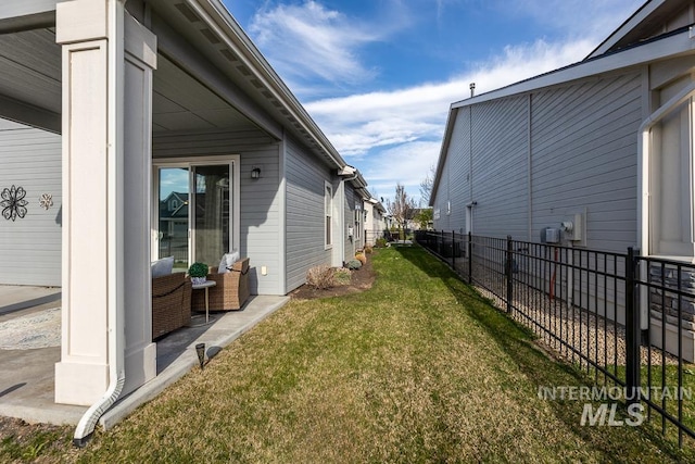 view of home's exterior with a lawn and fence