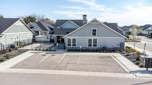exterior space featuring a residential view, central air condition unit, uncovered parking, and fence