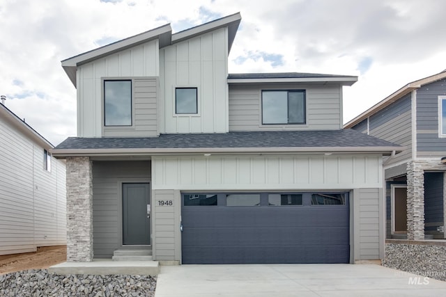 contemporary home featuring board and batten siding, driveway, a shingled roof, and an attached garage