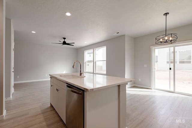 kitchen featuring hanging light fixtures, a sink, a kitchen island with sink, white cabinetry, and stainless steel dishwasher