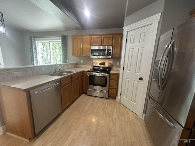 16928 N Chelford Loop, Nampa, ID 83687 - kitchen with stainless steel appliances, a sink, light wood-type flooring, brown cabinets, and light countertops