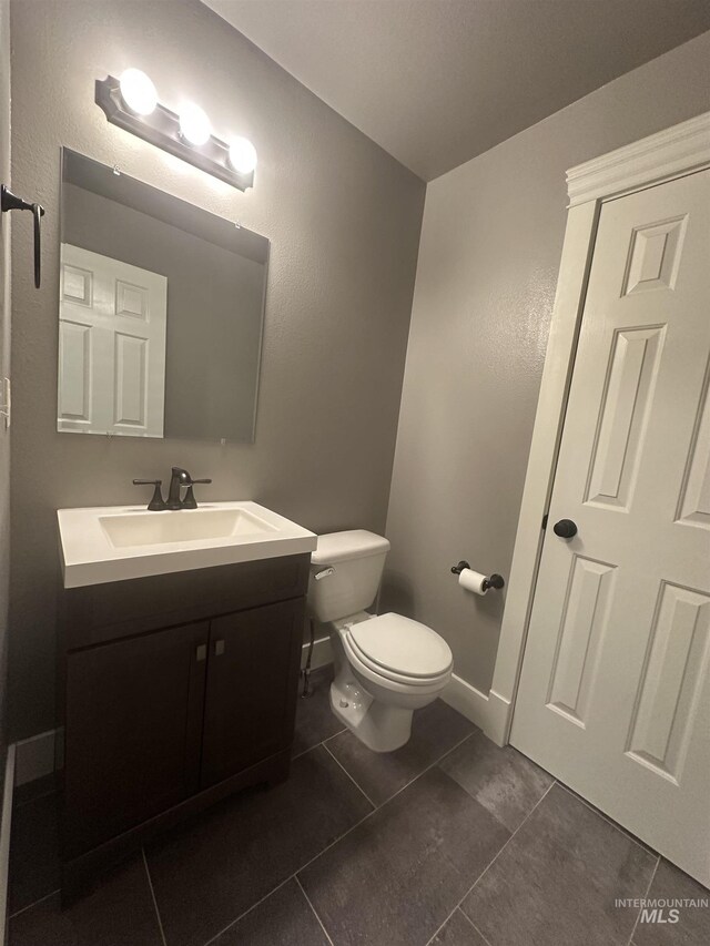16928 N Chelford Loop, Nampa, ID 83687 - bathroom with toilet, vanity, tile patterned flooring, and baseboards