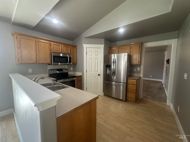 16928 N Chelford Loop, Nampa, ID 83687 - kitchen featuring stainless steel appliances, a sink, baseboards, a peninsula, and light wood-style flooring