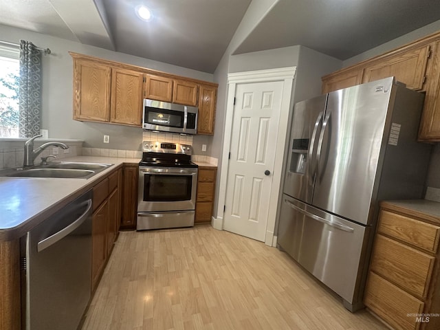 16928 N Chelford Loop, Nampa, ID 83687 - kitchen featuring appliances with stainless steel finishes, a sink, light wood-style floors, brown cabinets, and a peninsula