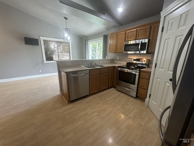 16928 N Chelford Loop, Nampa, ID 83687 - kitchen featuring appliances with stainless steel finishes, a sink, vaulted ceiling, a peninsula, and brown cabinets
