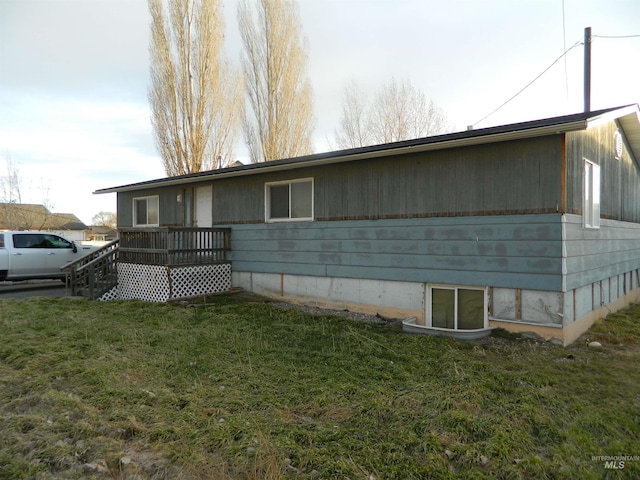 view of front of house with a deck and a front lawn