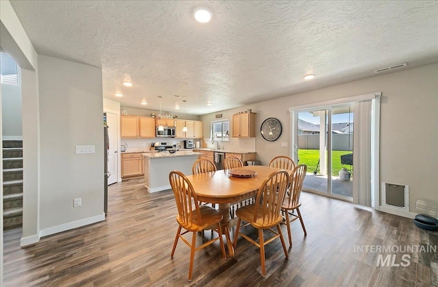 11299 W Taviton St, Nampa, ID 83651 - dining space featuring dark wood-type flooring, a textured ceiling, recessed lighting, stairs, and baseboards